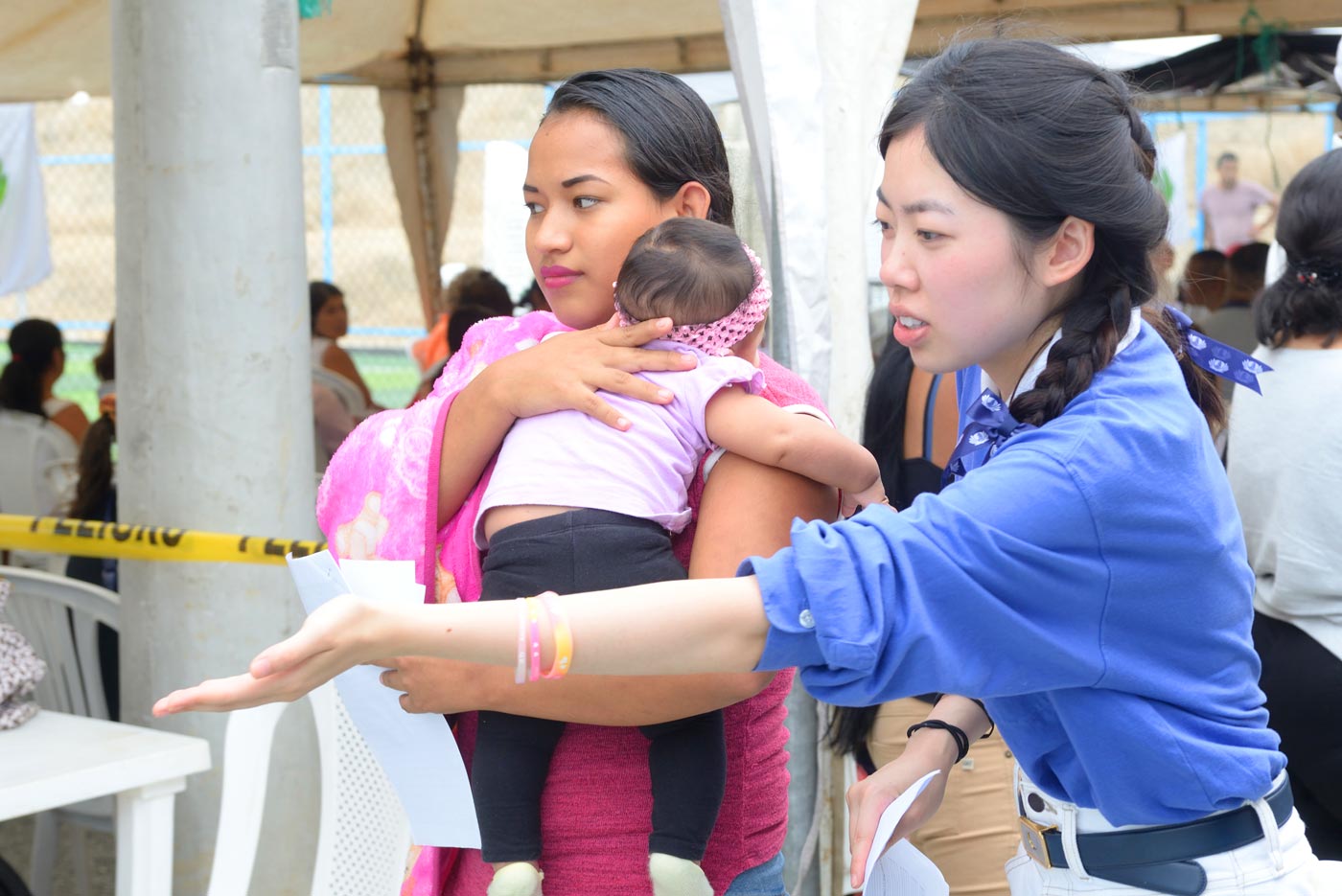 慈濟青年志工引領漁村年輕媽媽看診。攝影：朱澤人
