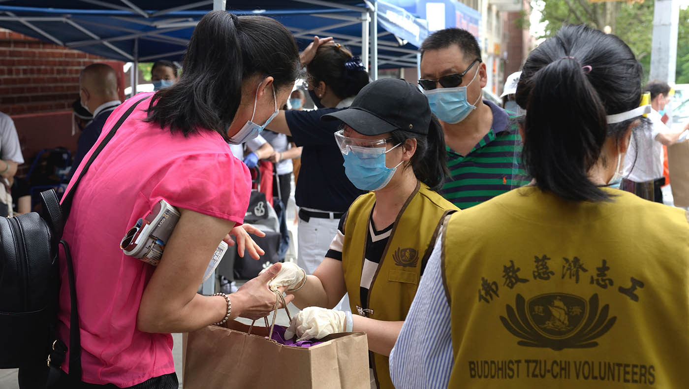 志工們把整袋的食物交給民眾。攝影／朱澤人