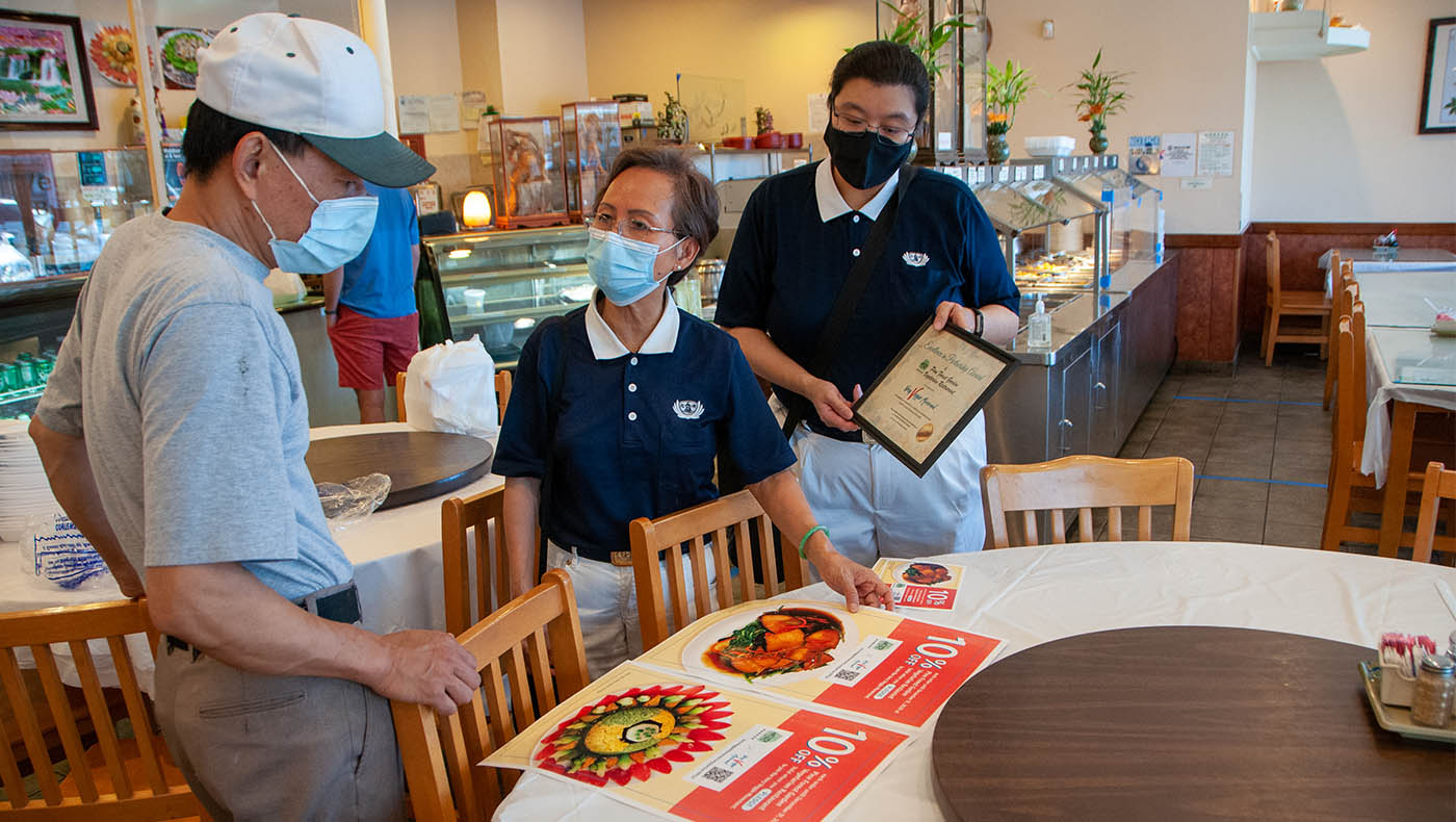 Volunteers deliver posters to Pine Forest Garden Vegetarian Restaurant. Photo by Roger Lin.