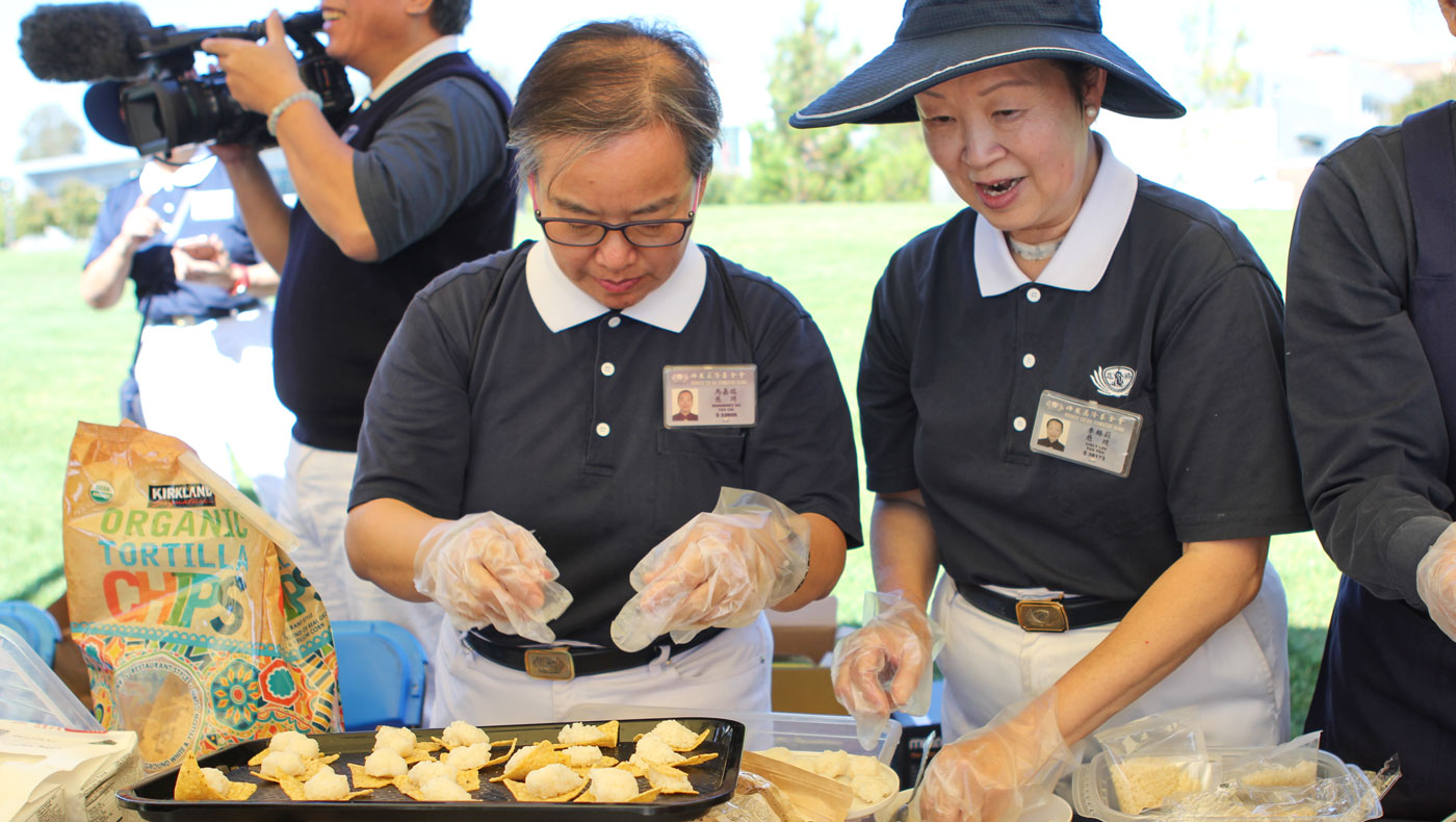 Tzu Chi volunteers prepare bite-sized Jing Si instant rice snacks for tasting. Photo by Michael Tseng.