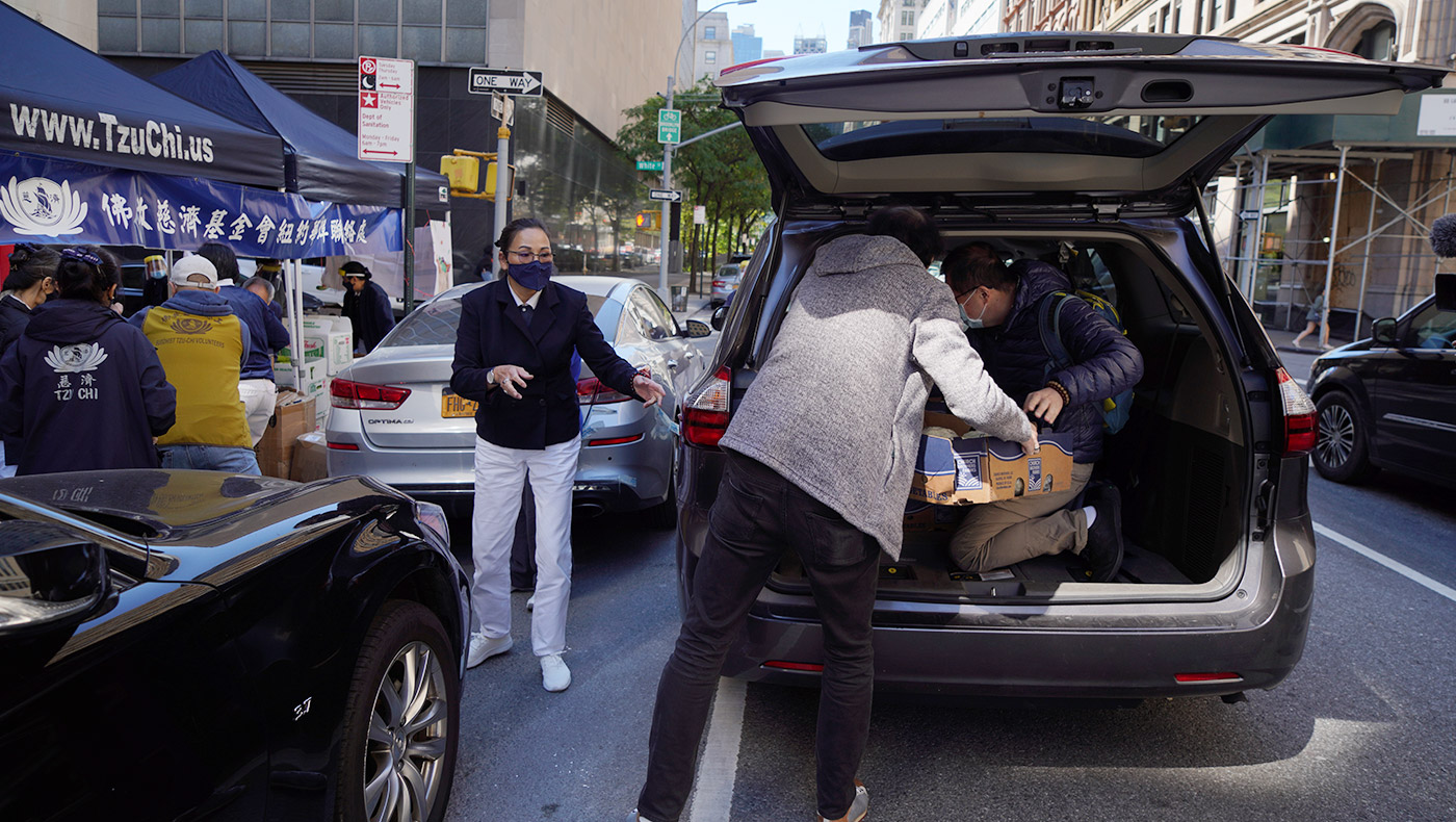 志工们出钱、出力、出车，在曼哈顿街道上卸下筹措来的大批新鲜蔬果。左中正对者为慈济志工沈卉。摄影／海克特