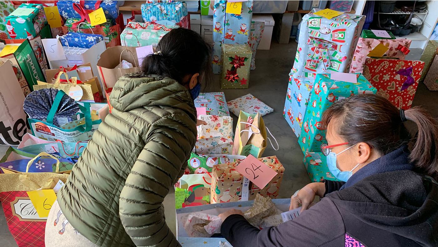 志工施藹珊及吳佩施（Jamie Wu）把同一個家庭包裝完畢的禮物裝袋綁在一起，並在禮物袋上貼上禮物收件人的名字及編號，便於十二日當天的發放。攝影 ／謝琇茹