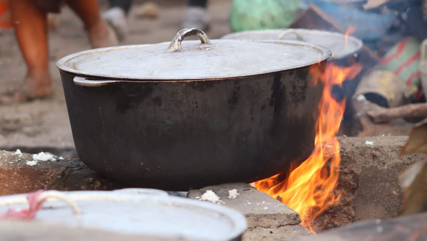 大鐵鍋就架在臨時搭建出來的爐灶上。圖片來源／獅子山共和國明愛會志工