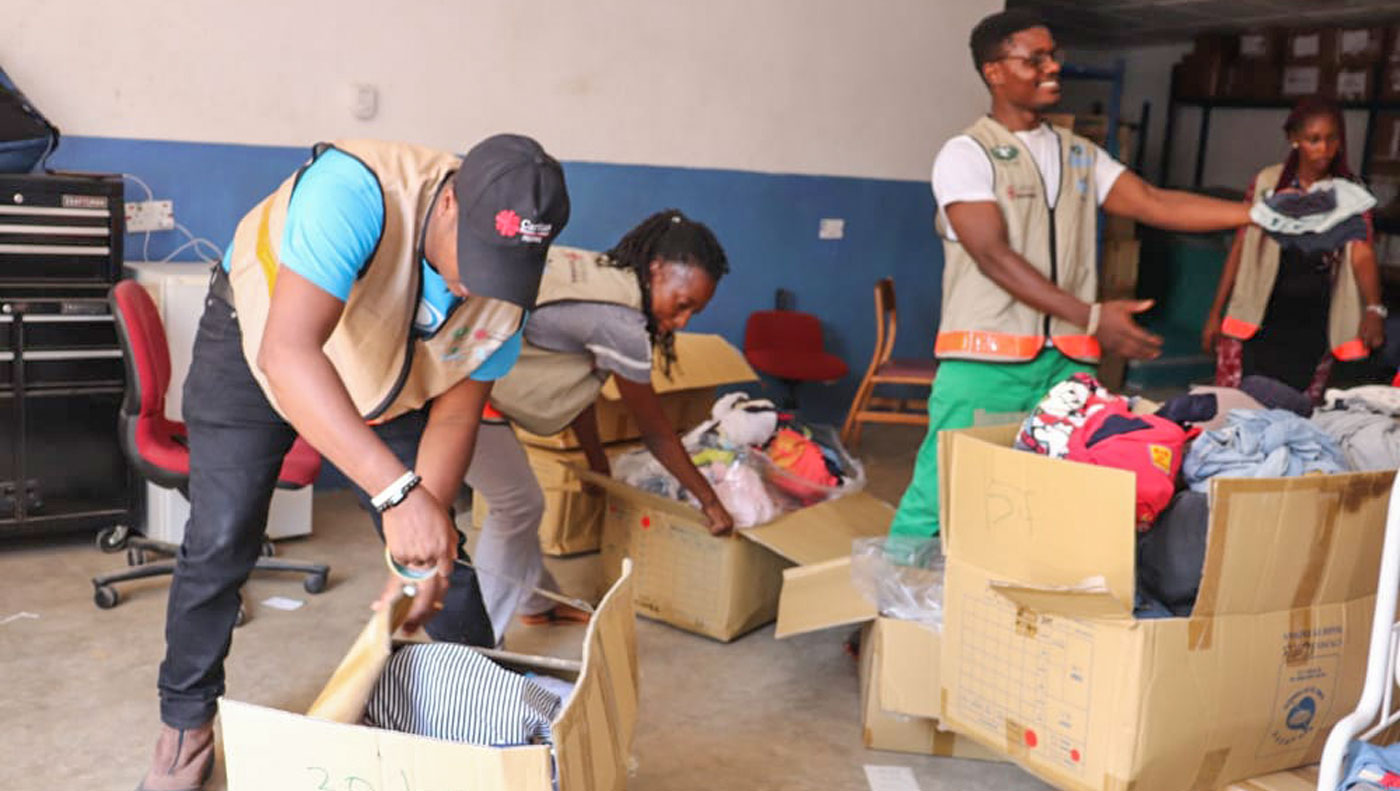 Volunteers help pack and prepare clean clothing for distribution. Photo/Desmond Jones and Mohamed Dakowa