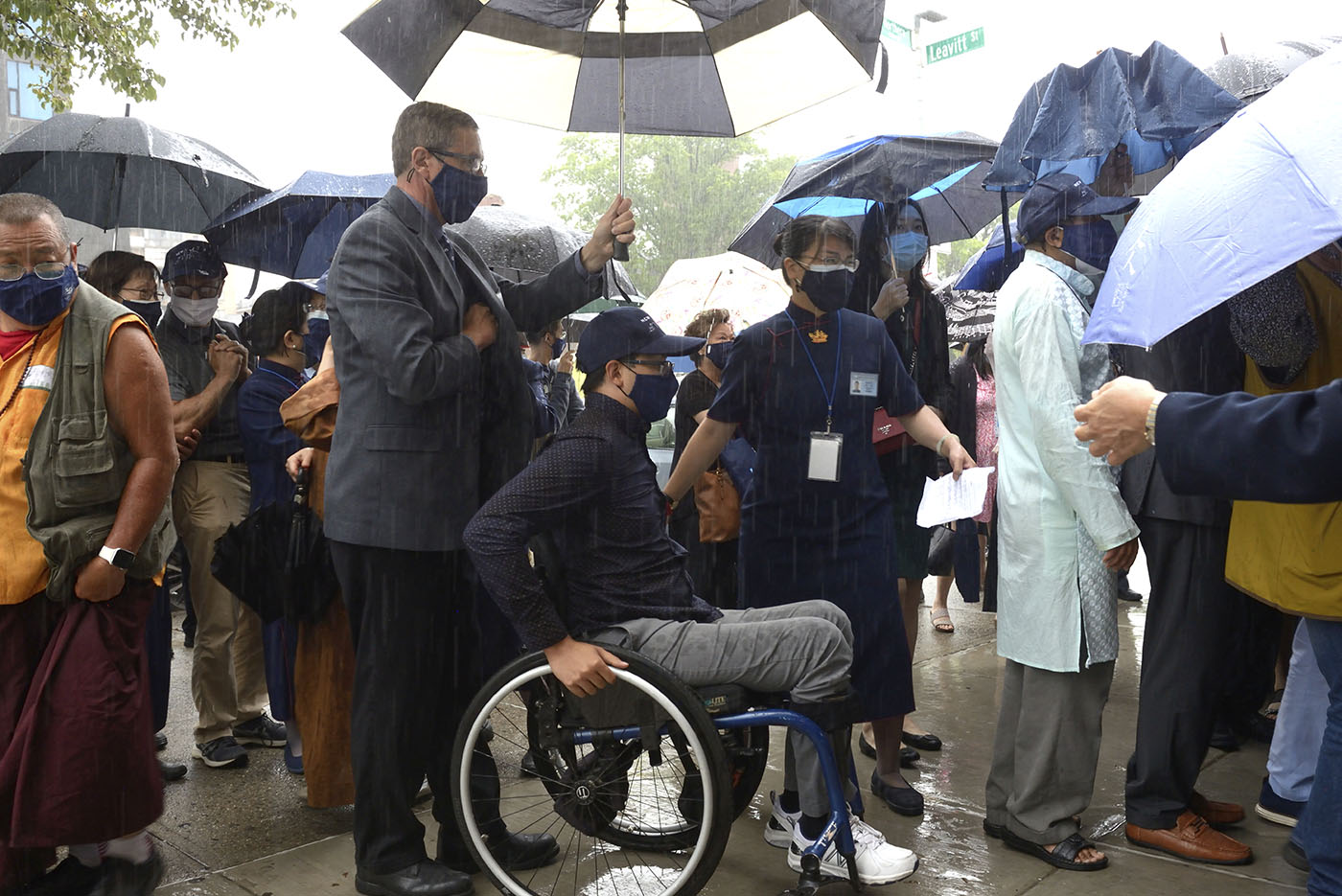 開幕典禮碰上大雨，慈濟志工引導鄭傳杰進入會所，他是2017年世界盃輪椅網球賽少年組冠軍。攝影／朱澤人