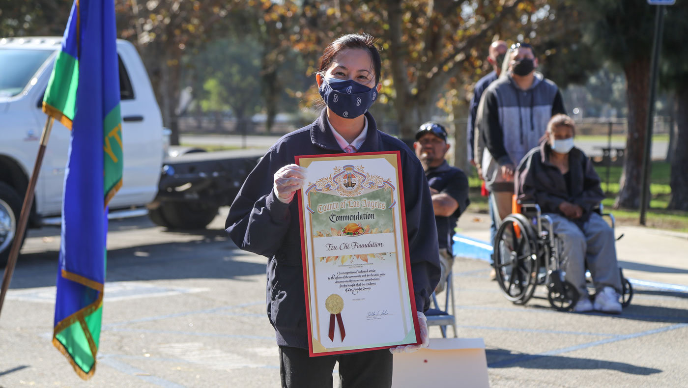 A Tzu Chi volunteer holds a certificate of commendation presented by LA County Supervisor Hilda L. Solis. Photo/Shuli Lo