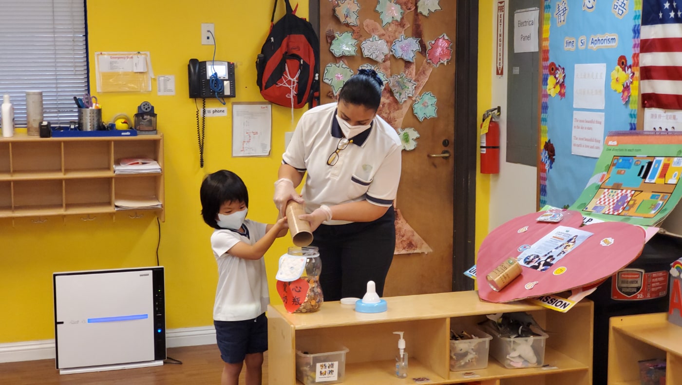 在此之後，學生又在老師的幫助下把積累在竹筒裡的錢幣會聚到愛心奶瓶裡。攝影／黃旭睦