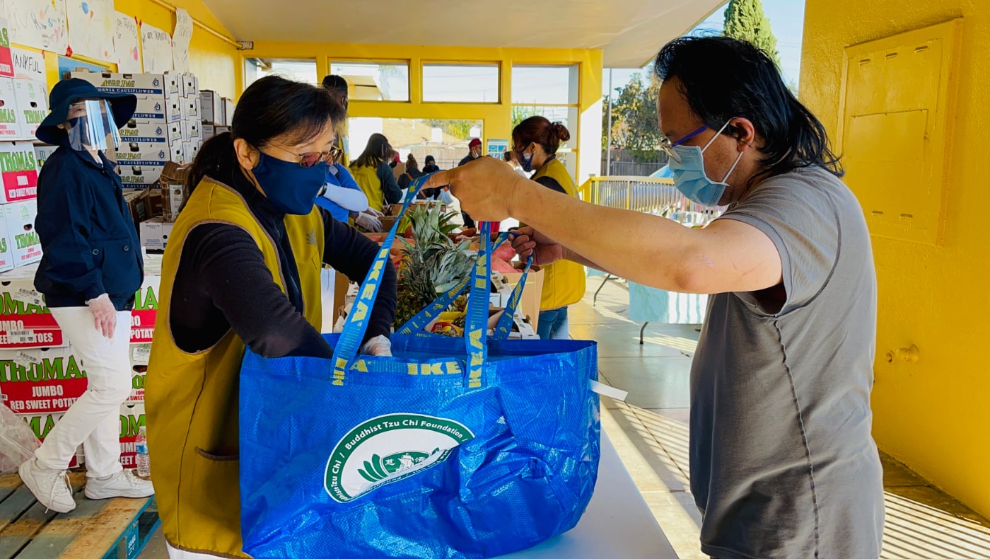 Tzu Chi USA’s Silicon Valley volunteers assist community residents as they pick up free pantry staples at the East Palo Alto Community Food Bank in preparation for the upcoming Thanksgiving holiday. Photo/Christina Chang