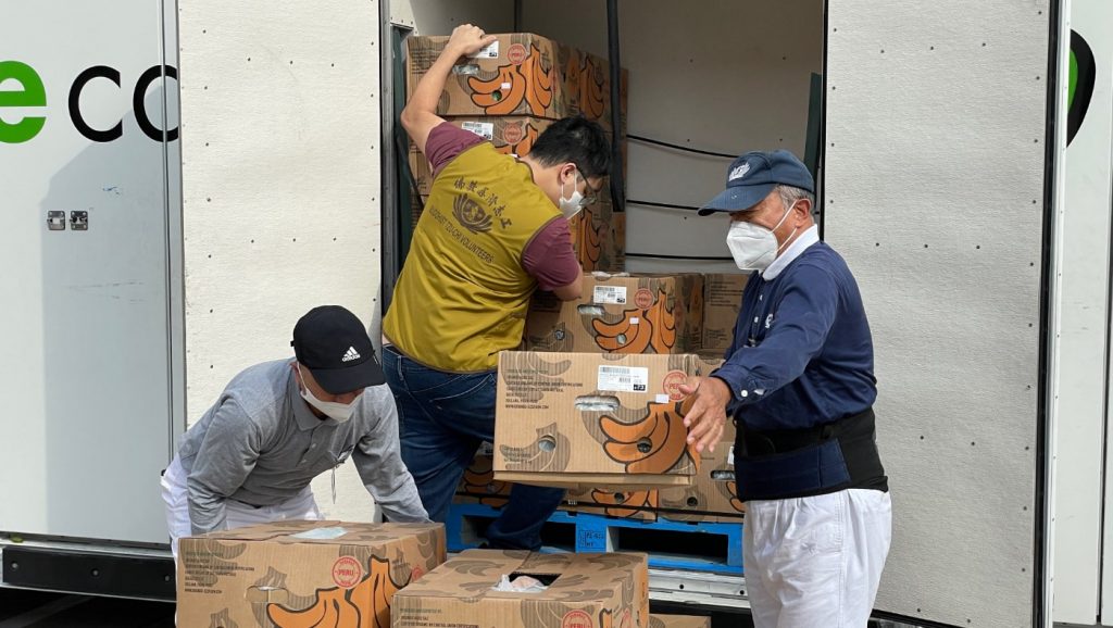 休士頓食物銀行的蔬果車抵達，志工們一起合作卸貨。攝影／吳育宗