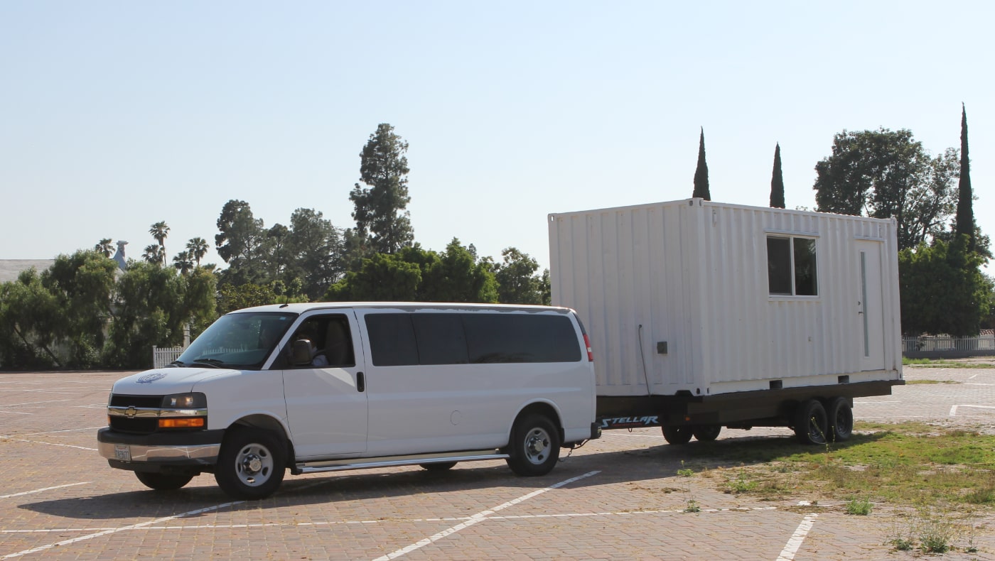 A van tows the mobile kitchen donated by the Los Angeles Regional Food Bank to the Tzu Chi USA Headquarters campus. Photo/Meizhen Qian