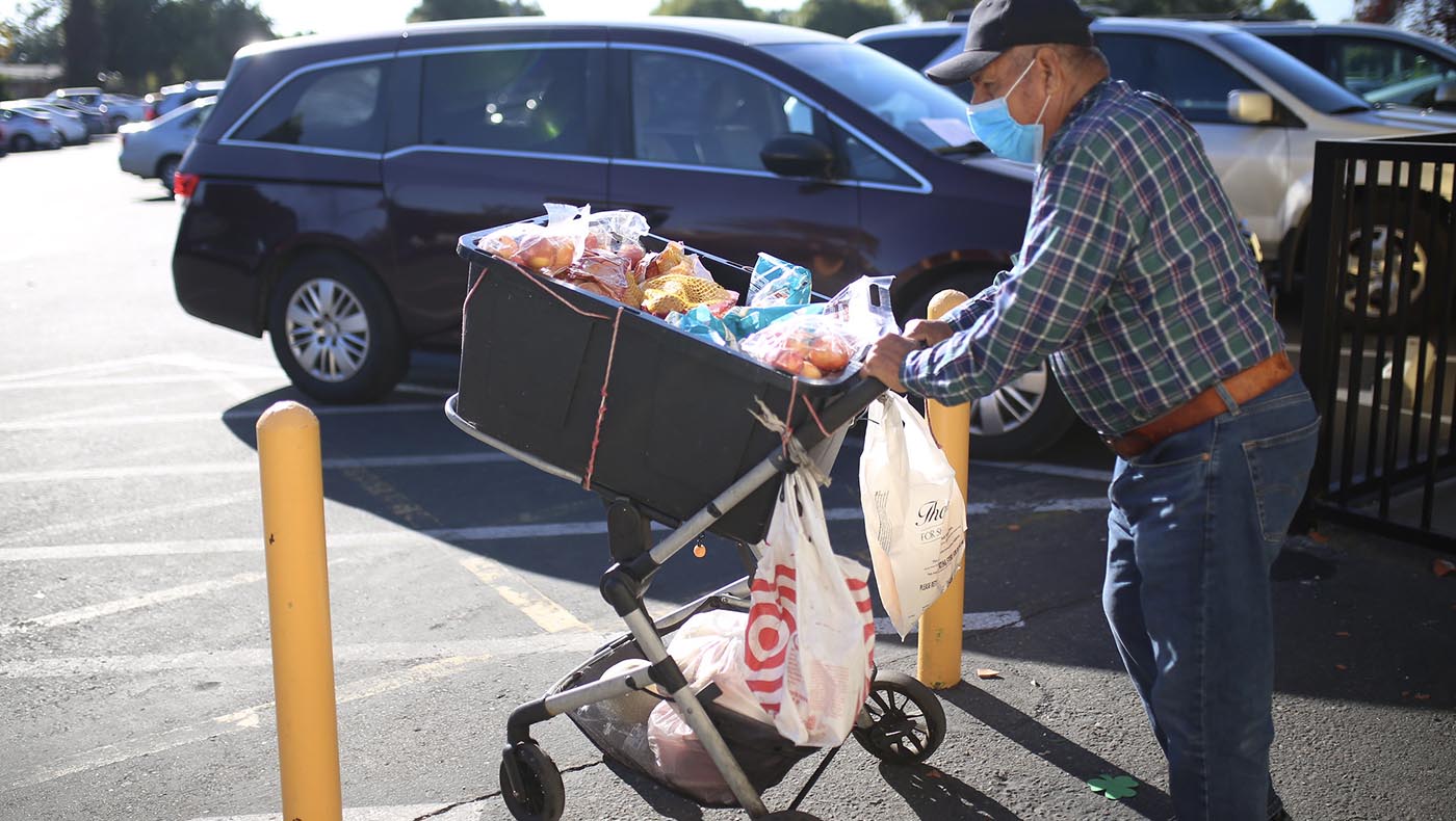 A man pushes a cart filled with food back home. Photo / Steven Chiu