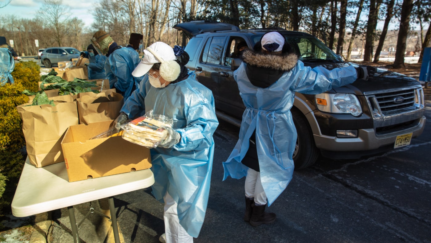 2021年1月29日，疫情期間，志工身著防護服在零下八度的室外搬運物資。圖片來源 / 新澤西分會