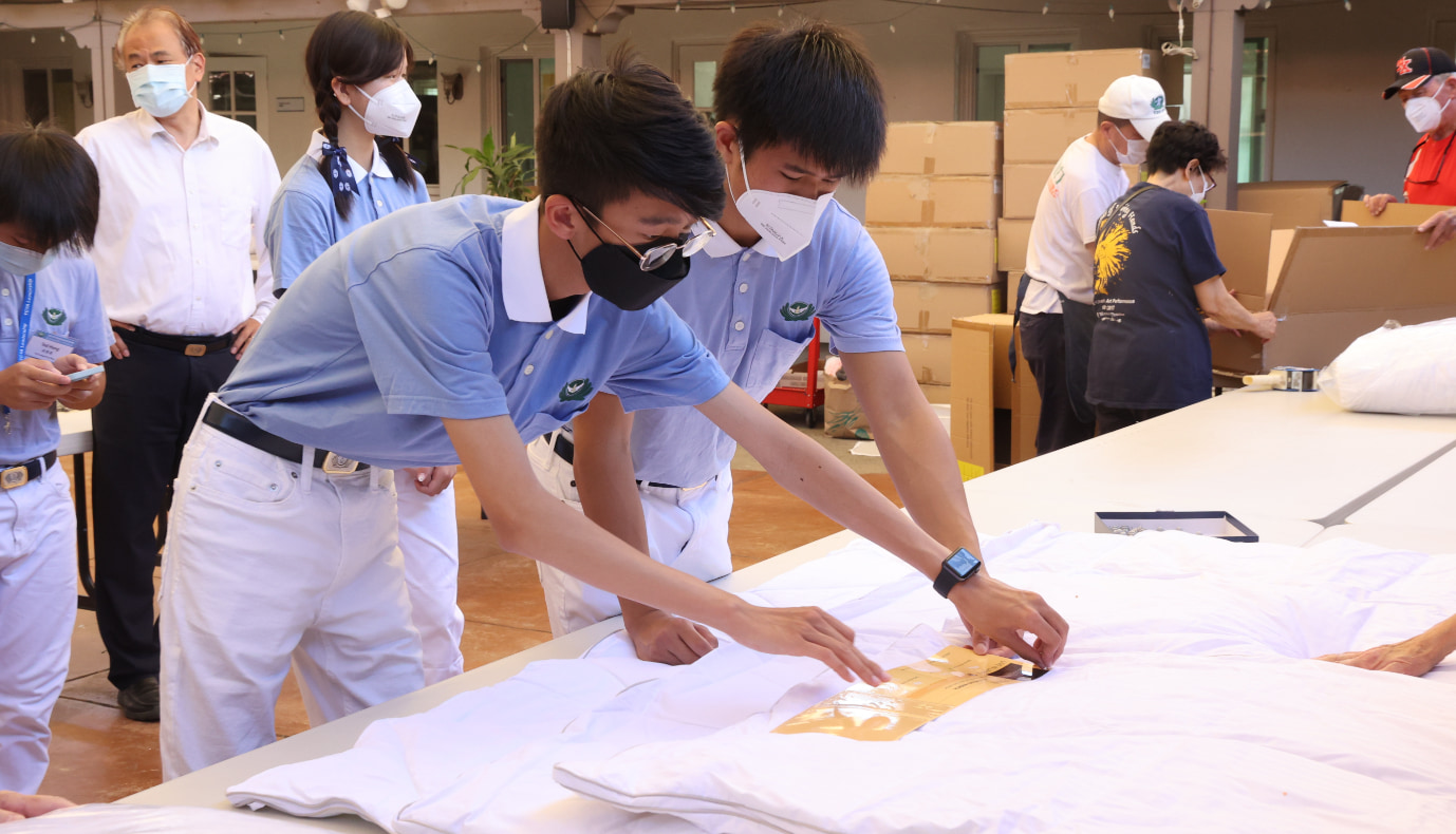 慈濟少年志工為整理好的棉被貼上慈濟標籤。攝影 / 駱淑麗