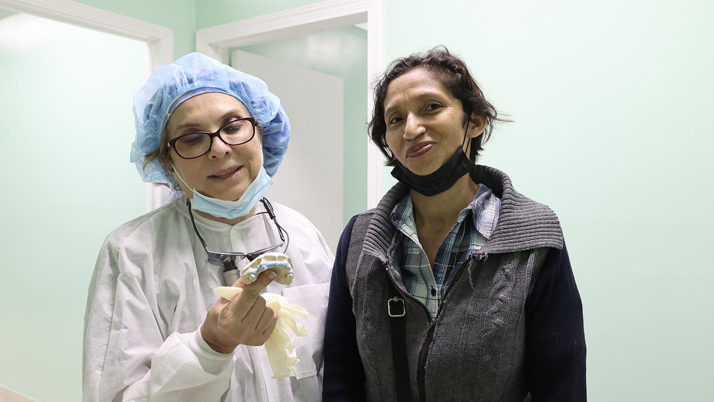 瑪莎·盧塞羅醫師（左）為病患塞維莉安娜裝上假牙，讓她願意開口說話。攝影／駱淑麗