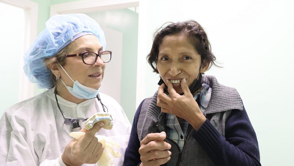Dr. Martha Rosa Lucero (left) fits patient Severiana Gutierrez with dentures