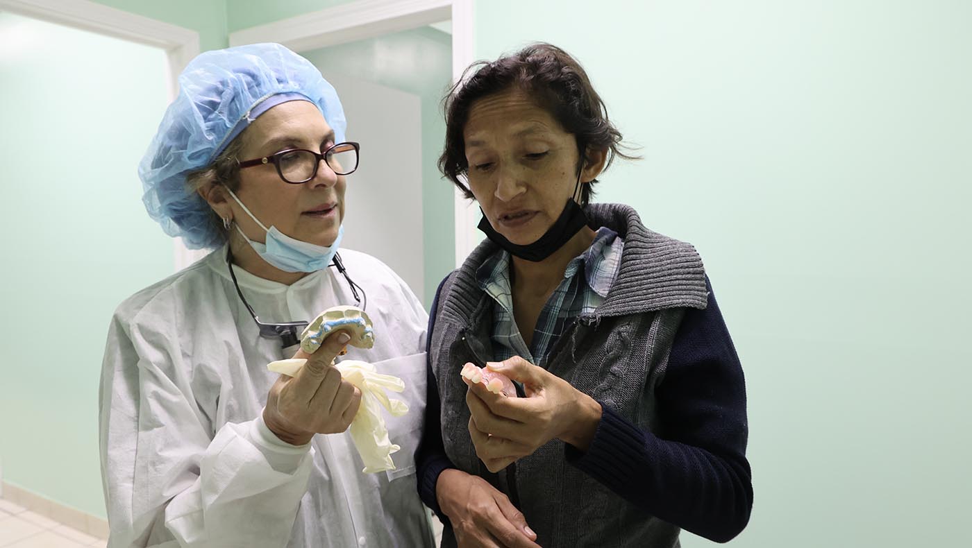瑪莎·盧塞羅醫師（左）為病患塞維莉安娜裝上假牙，讓她願意開口說話。攝影／駱淑麗