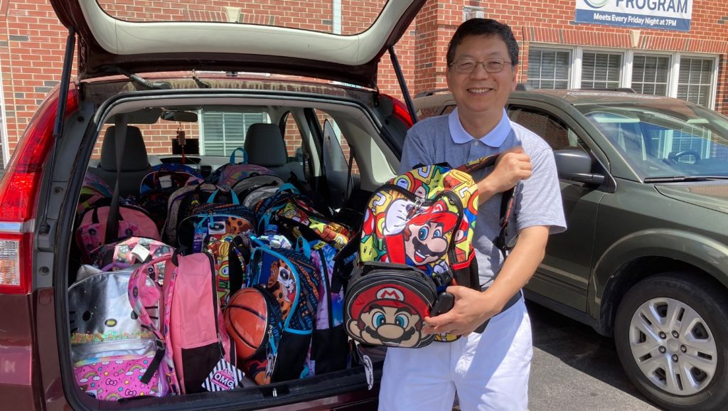 Zhixing Chen entrega mochilas llenas de útiles escolares a Durham Rescue Mission