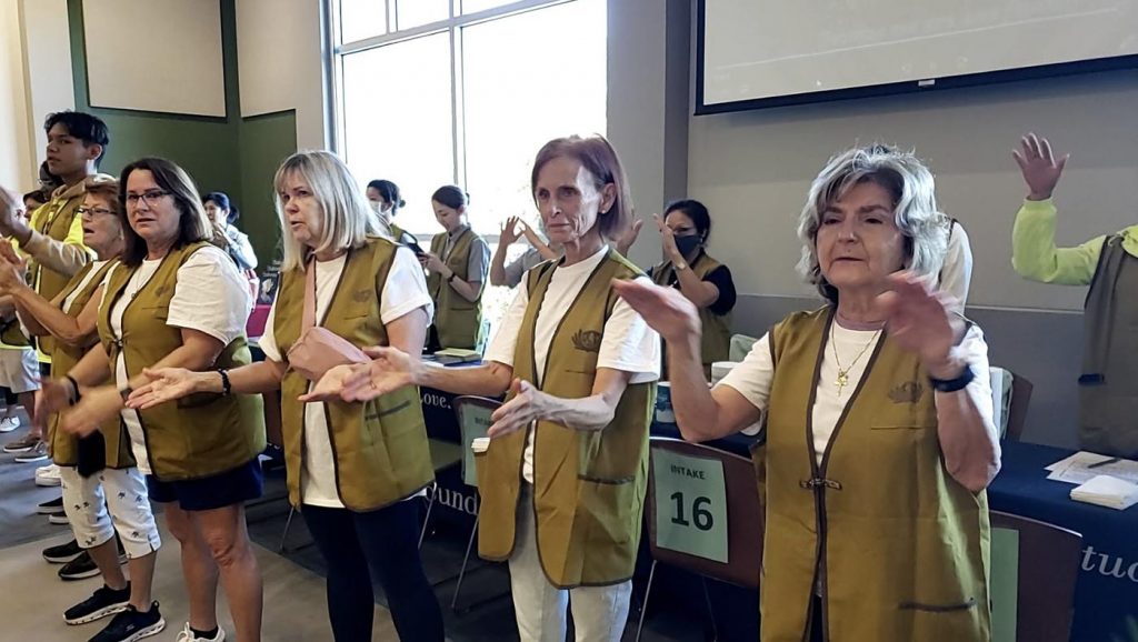 Tzu Chi Community volunteer Cynthia Schultz (front row, third right) and her friends learn some sign language gestures.
