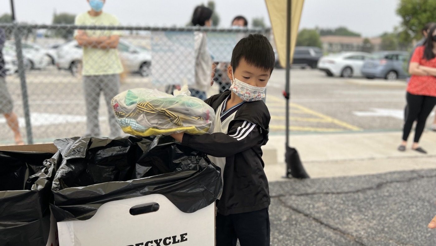 Elementary school student help out to put material on the truck