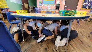 Students escape under the table during the earthquake drill