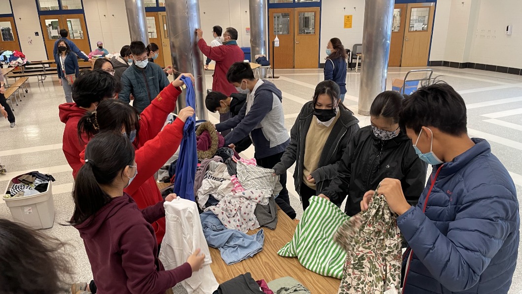 Tzu Chi Academy teachers and student organising second hand clothes