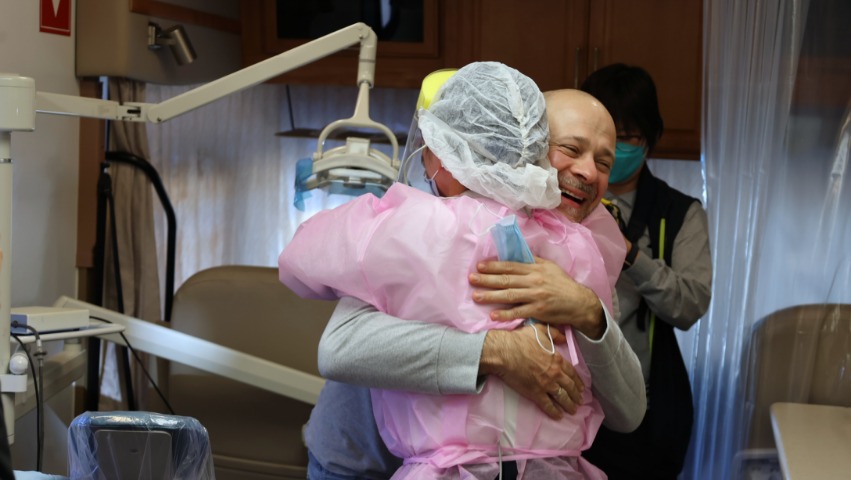 Man and dentist hugging