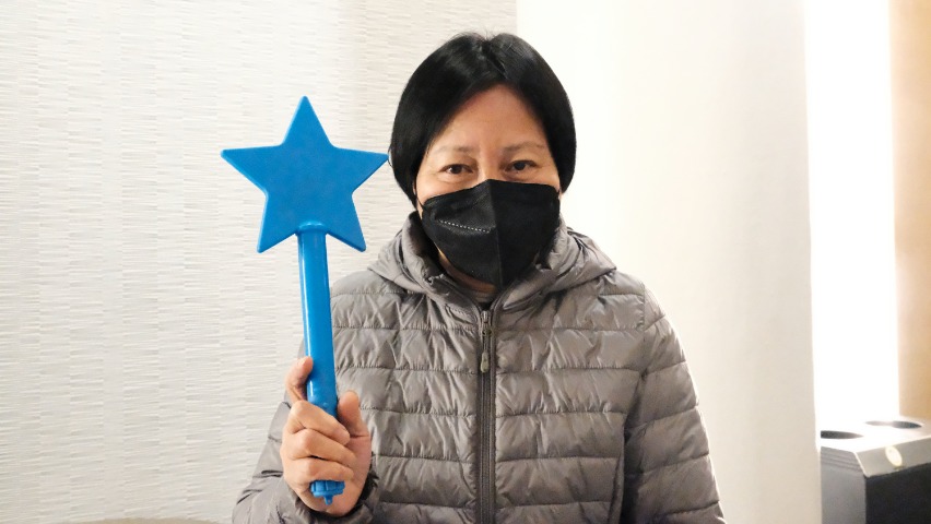 Audience Pamela Pan holding Tzu Chi NY 2022 Charity Concert blue star light