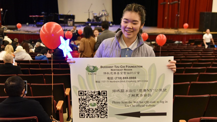 Tzu Ching from Tzu Chi Academy holding direction banner
