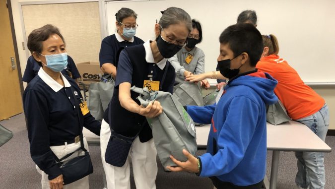 Tzu Chi volunteers distributing winter clothes to Landis Elementary School students