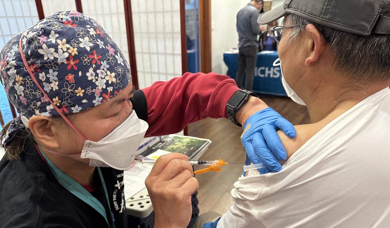 Tzu Chi volunteer giving free shot to Bellevue resident