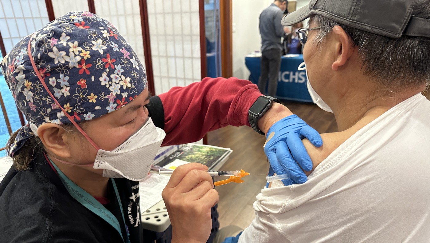Tzu Chi medical volunteer giving free shot to Bellevue resident