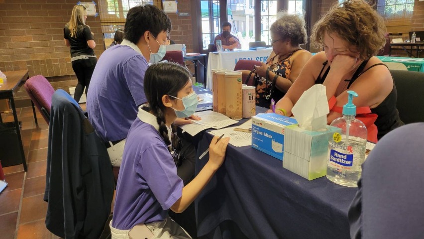 Tzu Chi volunteers assisting affected people fill out the forms
