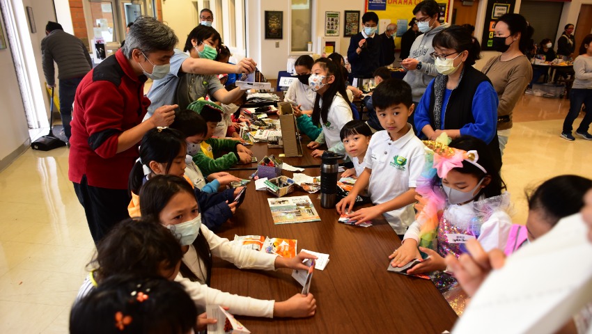 Tzu Chi Portland Academy teachers, parents and student using recycle paper to create origami trash bin