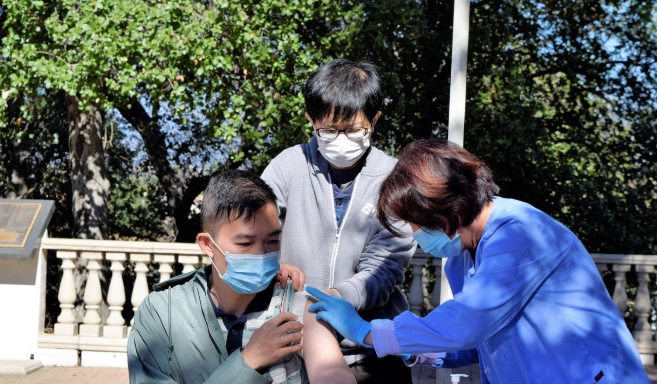 Tzu Chi medical volunteer giving free shots to LA resident