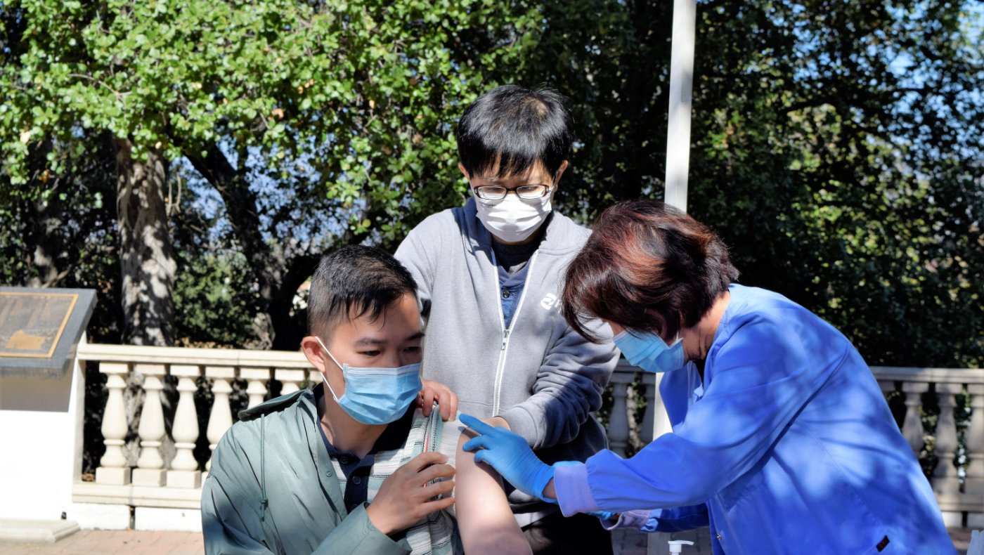 Tzu Chi medical volunteer giving free shots to LA resident