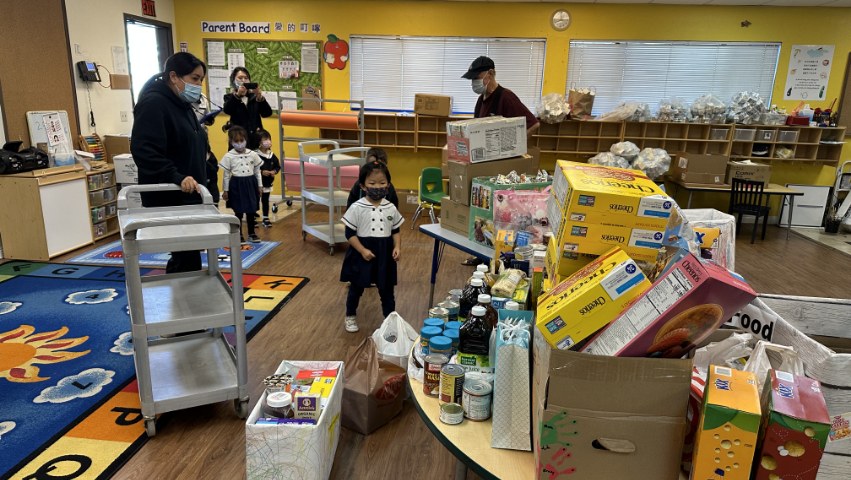 Tzu Chi Preschool students helping out to put the donation food in the storage room