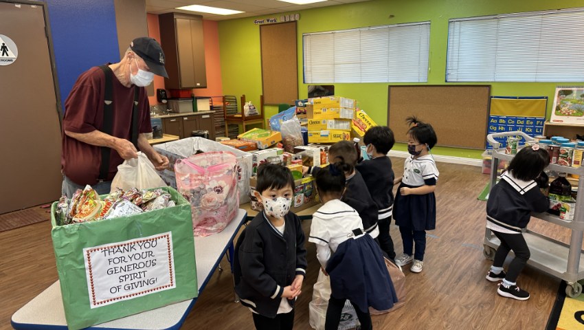 Tzu Chi Walnut Preschools students helping to put donation foods on the cart for the food bank
