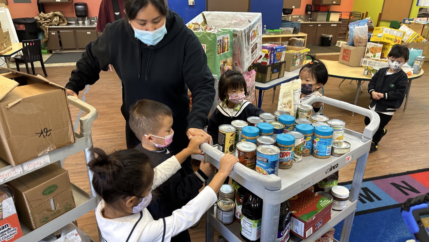 Tzu Chi Walnut Preschools students helping to put donation foods on the cart
