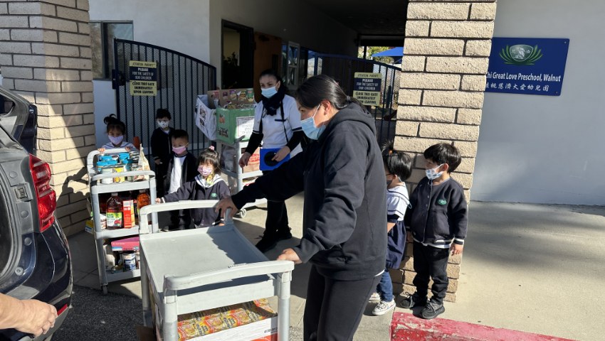 Tzu Chi Preschool students helping to put the donation food in the car back seat