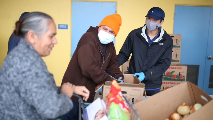 Kai carga y distribuye alimentos a las personas que se acercan a recogerlos.Foto/ Steven Chiu