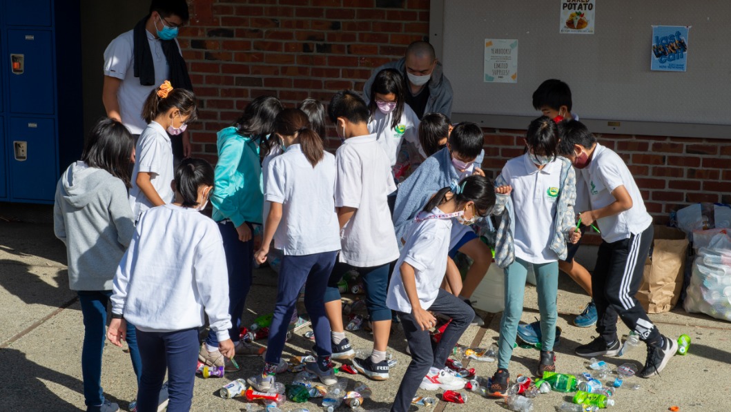 Cupertino Academy students stomp the bottles together for recycling