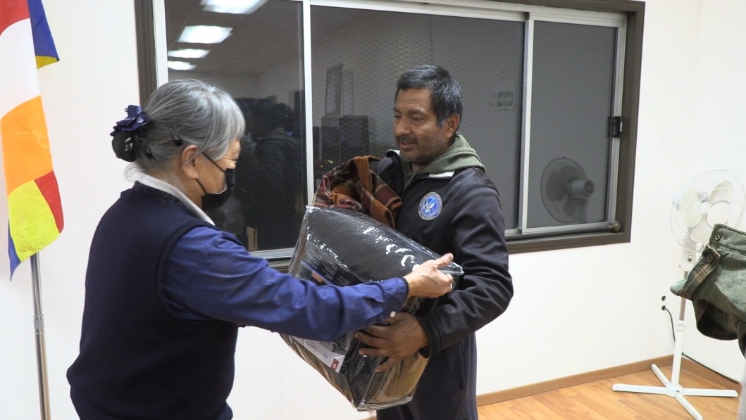 Tzu Chi volunteer giving Christmas present to people in Tijuana