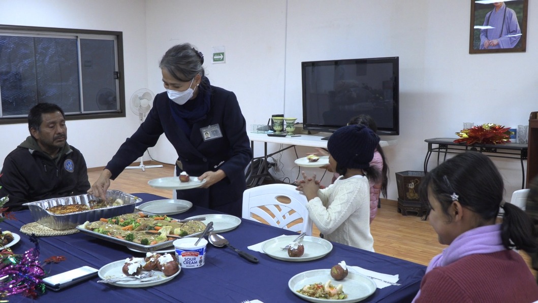 Tzu Chi volunteer distributing food to family from Tujuana