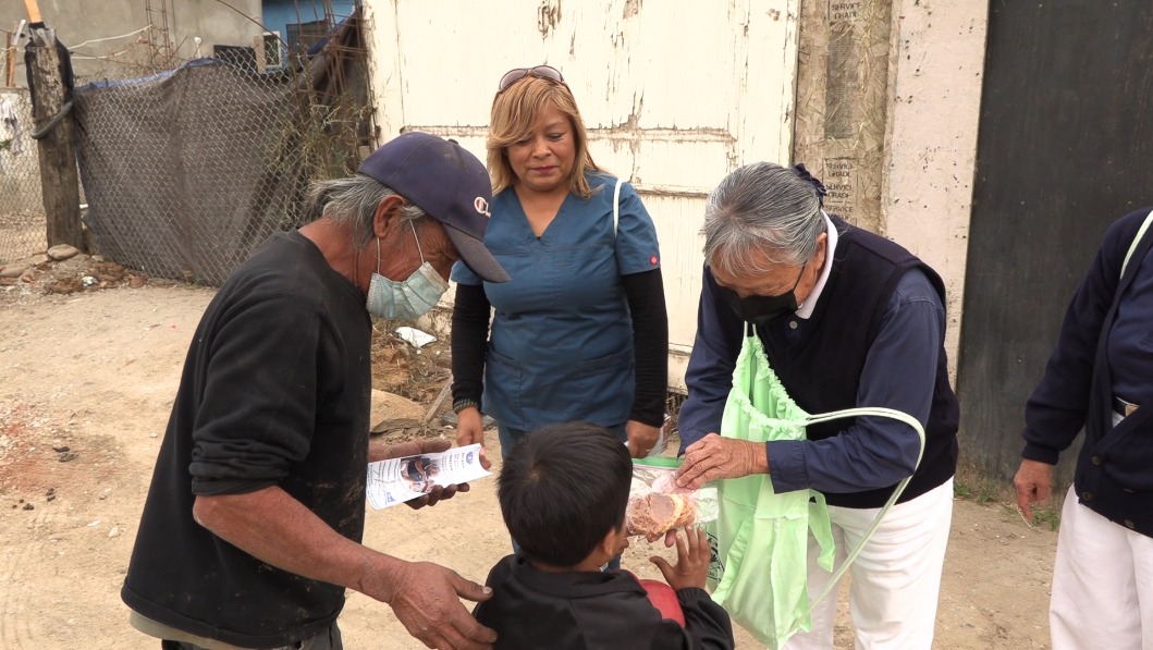 Tzu Chi volunteers giving snacks to people in Tijuana