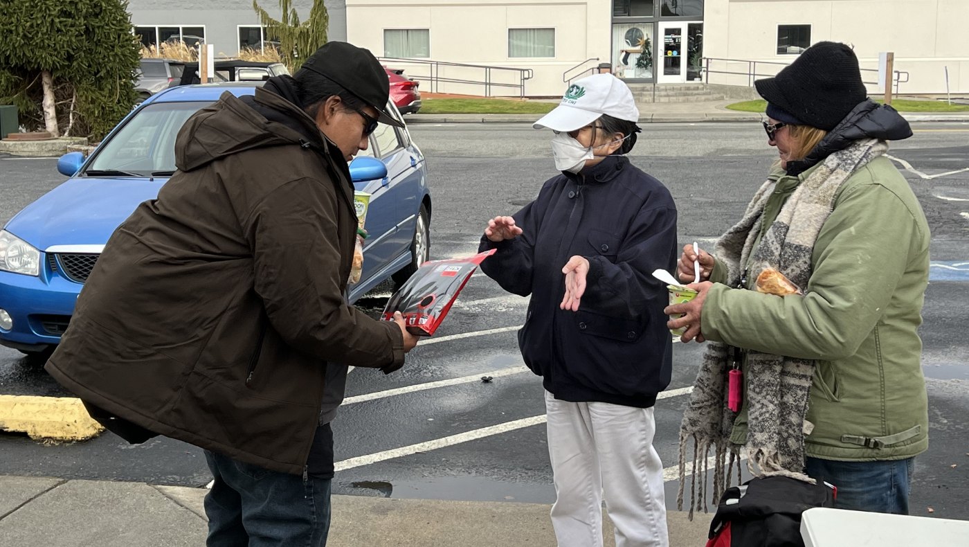 Tzu Chi volunteers explaining care recipient how to use the distribution item