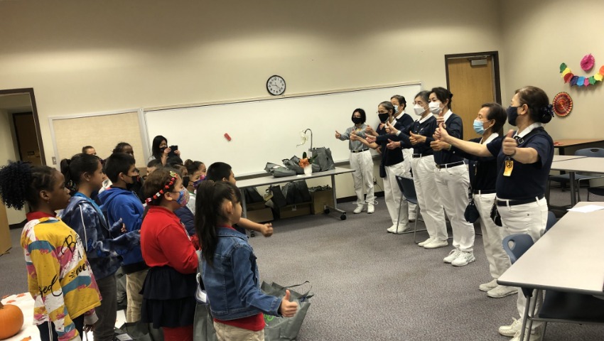 Los voluntarios de Tzu Chi enseñan la canción “Amor y Compasión”, en lenguaje de señas a los estudiantes. Foto/ Lijuan Xiao