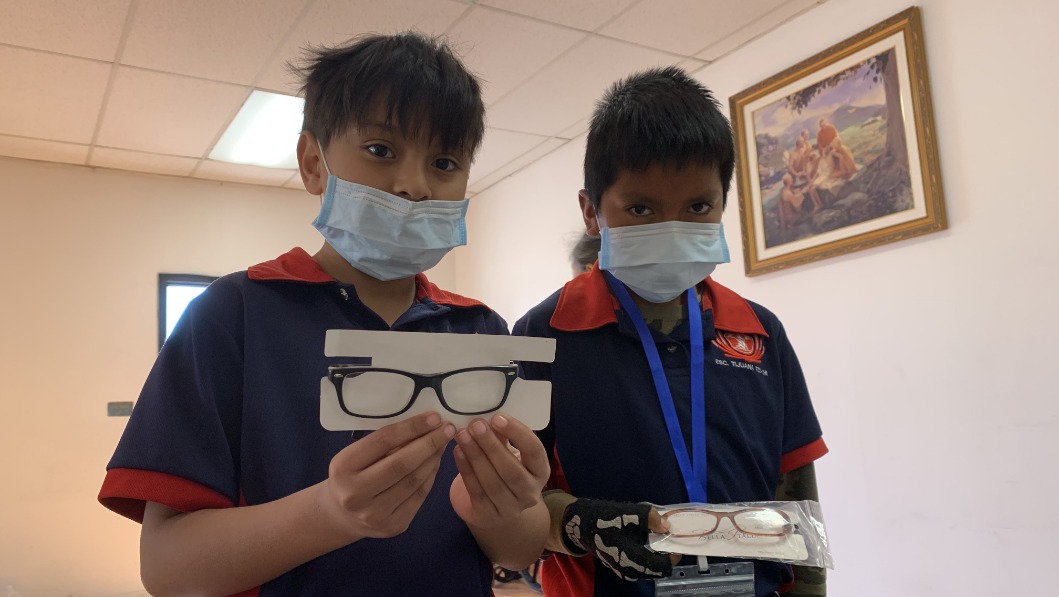 Students from Tijuana hold their first pair of glasses