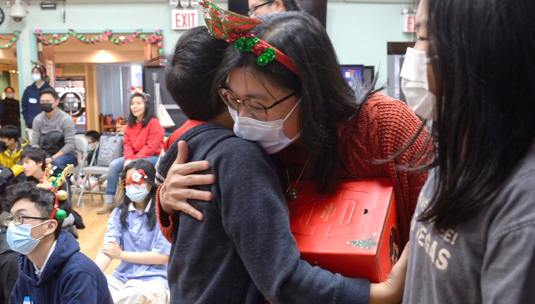 Kid giving Christmas gift to his parent in Tzu Chi New York Tzu Shao Christmas Day