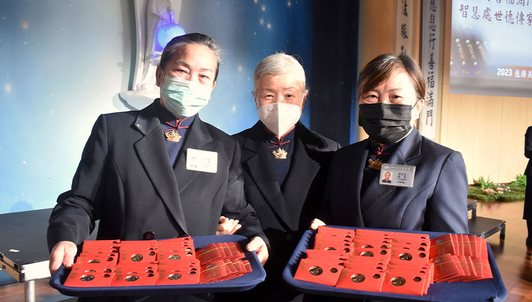 Tzu Chi USA members holding blessing red envelope from Master Cheng Yen