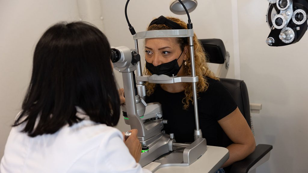 Optometric medical volunteers examine patients' eyes.